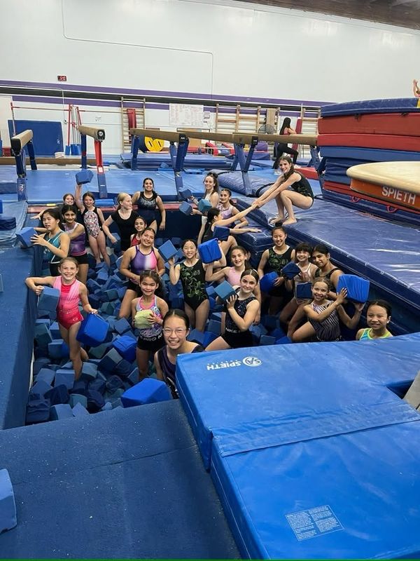 Gymnastics East athletes smiling in the foam pit